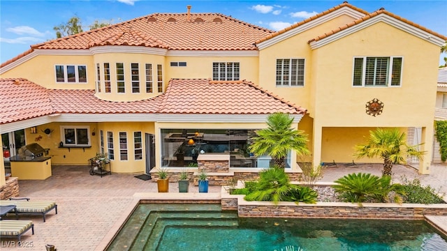 7428 Doe Ave, Las Vegas, NV 89117 - rear view of house with an outdoor kitchen, stucco siding, a tile roof, an outdoor pool, and a patio area