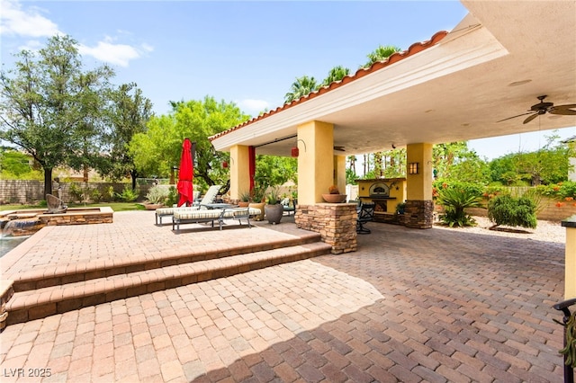 7428 Doe Ave, Las Vegas, NV 89117 - fenced backyard with an outdoor stone fireplace, a patio, a hot tub, and ceiling fan