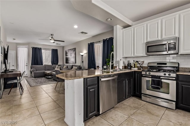 1739 Spanish Sky Ave, Las Vegas, NV 89183 - kitchen with appliances with stainless steel finishes, white cabinetry, dark cabinetry, a peninsula, and recessed lighting