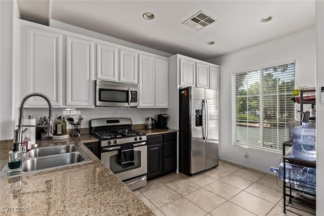 1739 Spanish Sky Ave, Las Vegas, NV 89183 - kitchen featuring stainless steel appliances, white cabinetry, light tile patterned floors, tasteful backsplash, and recessed lighting