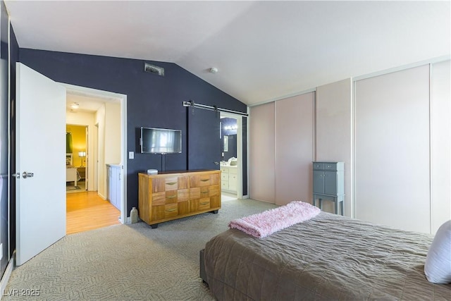 3650 Russian Olive St, North Las Vegas, NV 89032 - bedroom with two closets, lofted ceiling, light carpet, a barn door, and ensuite bath
