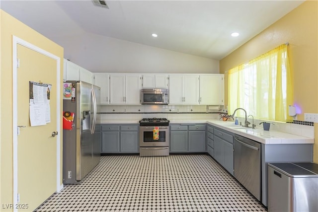 3650 Russian Olive St, North Las Vegas, NV 89032 - kitchen with stainless steel appliances, lofted ceiling, gray cabinetry, light flooring, and white cabinets
