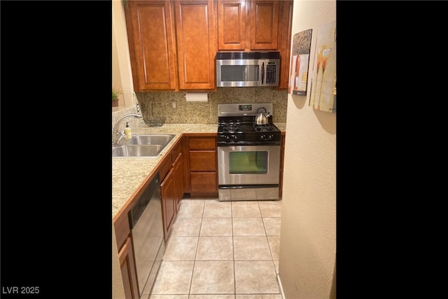 7155 S Durango Dr Unit 102, Las Vegas, NV 89113 - kitchen with appliances with stainless steel finishes, light countertops, light tile patterned flooring, brown cabinetry, and a textured wall