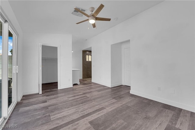 6129 Bedrock Ct, North Las Vegas, NV 89031 - unfurnished bedroom featuring multiple windows, wood finished floors, a walk in closet, and a closet