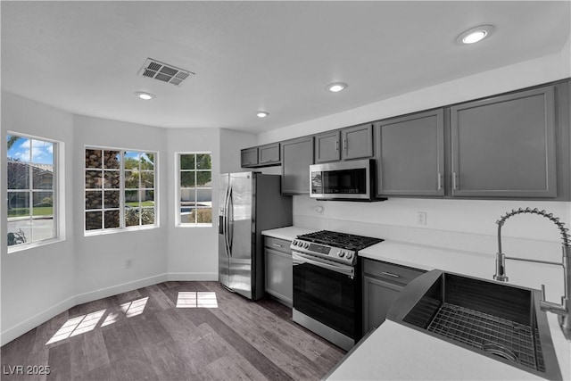 6129 Bedrock Ct, North Las Vegas, NV 89031 - kitchen featuring stainless steel appliances, healthy amount of natural light, dark wood-style floors, recessed lighting, and light countertops