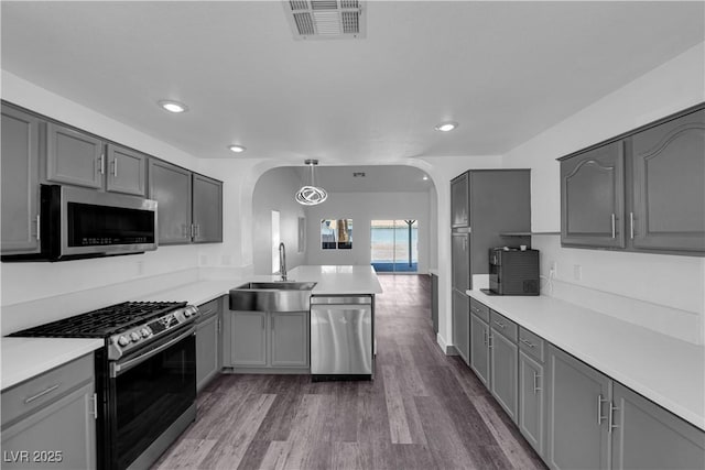 6129 Bedrock Ct, North Las Vegas, NV 89031 - kitchen with stainless steel appliances, arched walkways, gray cabinetry, and recessed lighting