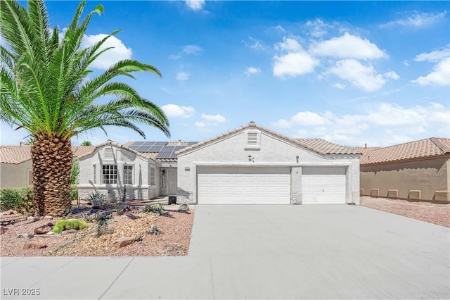 6129 Bedrock Ct, North Las Vegas, NV 89031 - ranch-style house featuring an attached garage, driveway, roof mounted solar panels, stucco siding, and a tiled roof