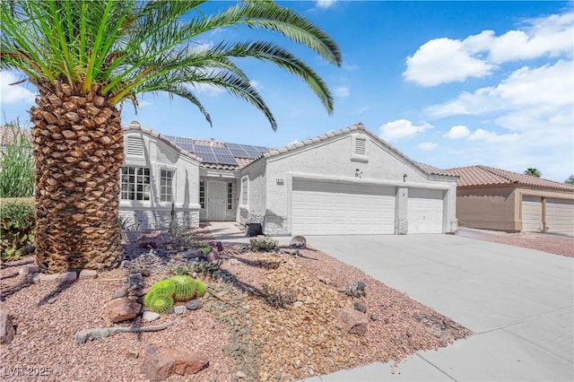 6129 Bedrock Ct, North Las Vegas, NV 89031 - ranch-style home with a garage, driveway, solar panels, stucco siding, and a tile roof