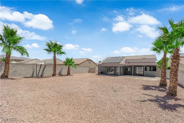 6129 Bedrock Ct, North Las Vegas, NV 89031 - back of house featuring roof mounted solar panels, a patio, a fenced backyard, a tiled roof, and stucco siding