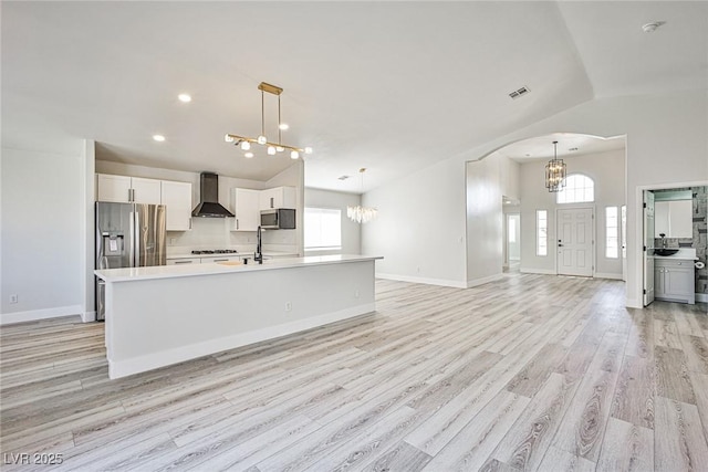 1002 Christopher View Ave, North Las Vegas, NV 89032 - kitchen featuring wall chimney range hood, a chandelier, lofted ceiling, healthy amount of natural light, and light wood finished floors