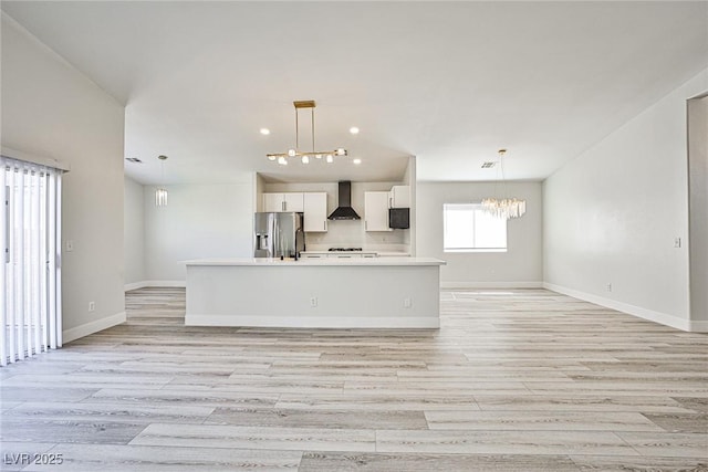 1002 Christopher View Ave, North Las Vegas, NV 89032 - kitchen with stainless steel fridge with ice dispenser, wall chimney exhaust hood, open floor plan, white cabinets, and light countertops