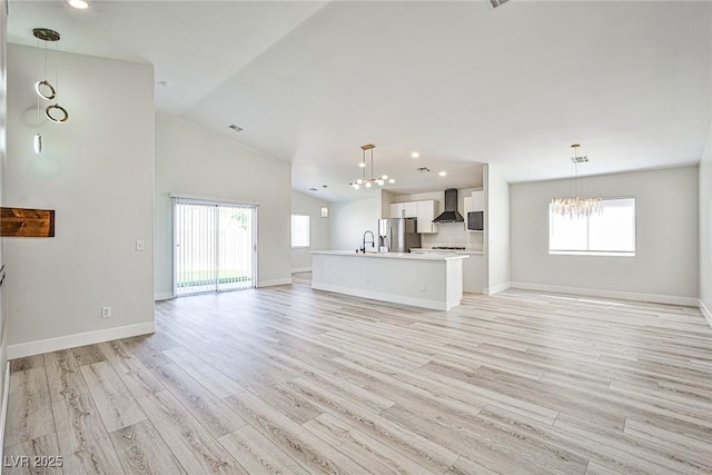 1002 Christopher View Ave, North Las Vegas, NV 89032 - unfurnished living room featuring a chandelier, light wood-style floors, recessed lighting, and lofted ceiling