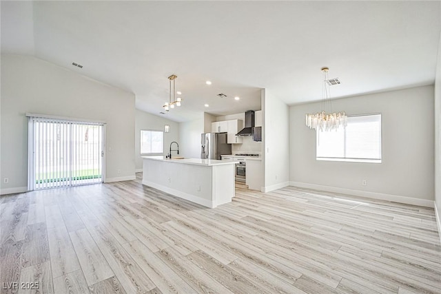 1002 Christopher View Ave, North Las Vegas, NV 89032 - unfurnished living room featuring a chandelier, lofted ceiling, and light wood-style flooring