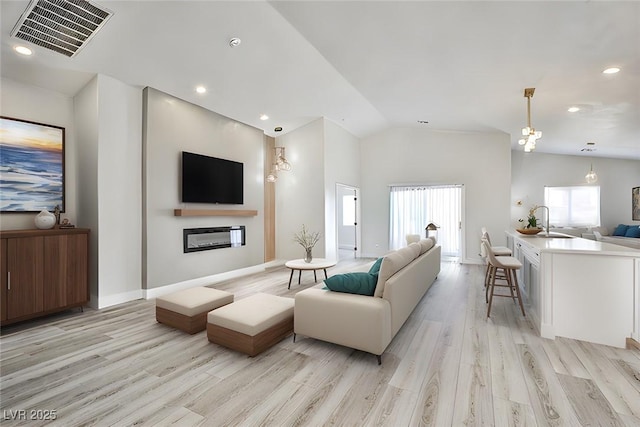 1002 Christopher View Ave, North Las Vegas, NV 89032 - living room featuring vaulted ceiling, light wood-style flooring, and recessed lighting
