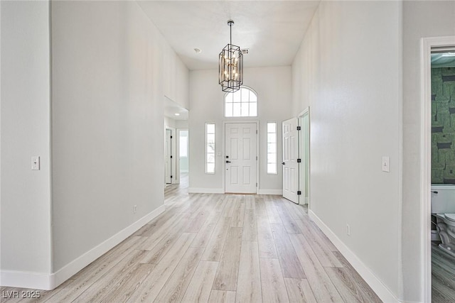 1002 Christopher View Ave, North Las Vegas, NV 89032 - entryway with light wood finished floors, a chandelier, and a high ceiling
