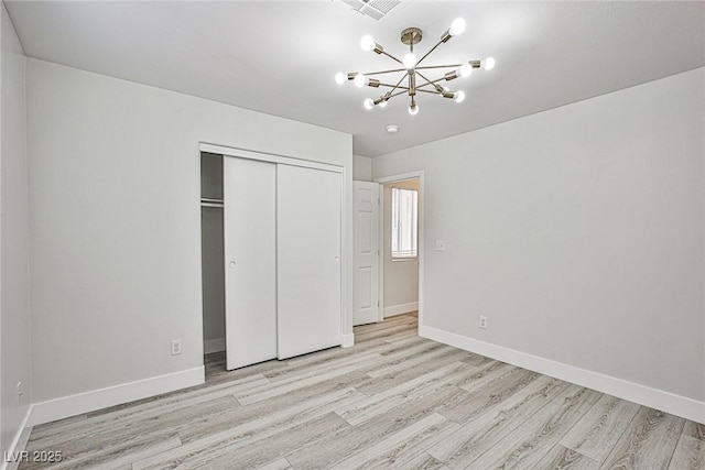 1002 Christopher View Ave, North Las Vegas, NV 89032 - unfurnished bedroom with light wood-style floors, a chandelier, and a closet
