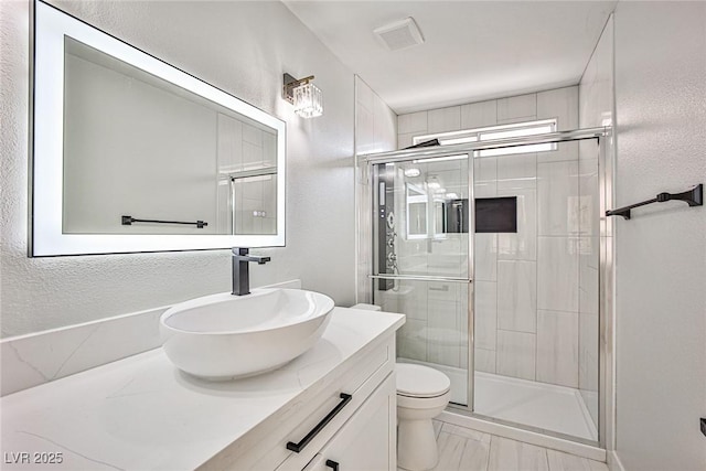 1002 Christopher View Ave, North Las Vegas, NV 89032 - full bathroom featuring vanity, a shower stall, and a textured wall