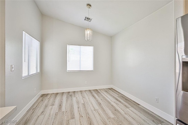 1002 Christopher View Ave, North Las Vegas, NV 89032 - unfurnished dining area featuring wood finished floors, plenty of natural light, vaulted ceiling, and a chandelier
