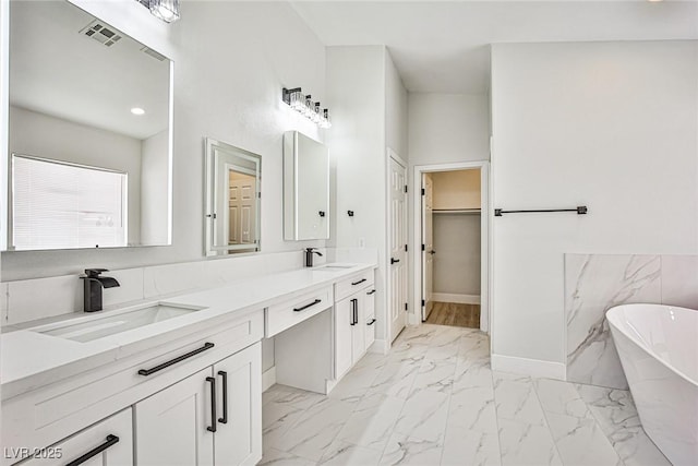1002 Christopher View Ave, North Las Vegas, NV 89032 - full bathroom featuring marble look tile flooring, double vanity, a soaking tub, and a spacious closet