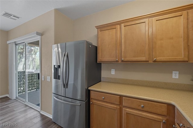 4625 Centisimo Dr Unit 202, North Las Vegas, NV 89084 - kitchen with stainless steel fridge with ice dispenser, wood finished floors, light countertops, and brown cabinetry