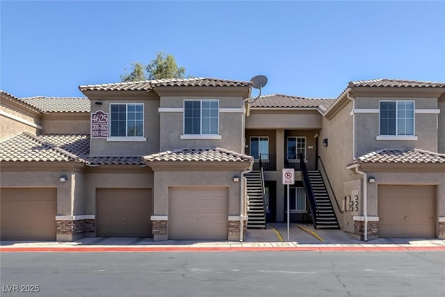 4625 Centisimo Dr Unit 202, North Las Vegas, NV 89084 - view of property featuring stucco siding, stairs, a tile roof, and stone siding