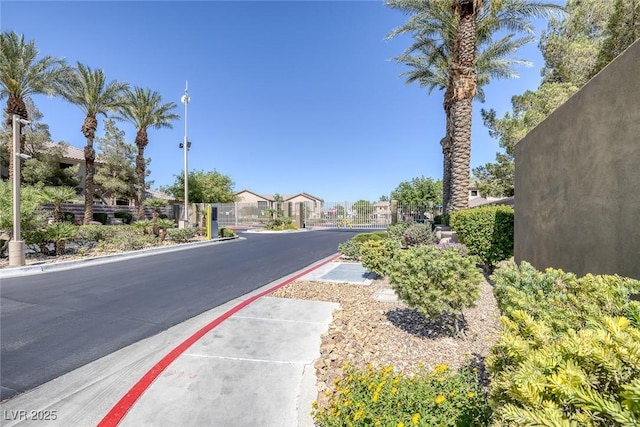4625 Centisimo Dr Unit 202, North Las Vegas, NV 89084 - view of asphalt road featuring a gate, sidewalks, a residential view, a gated entry, and street lights