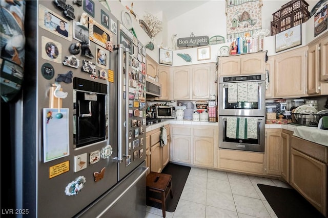 3648 Glen Ridge Way, Las Vegas, NV 89108 - kitchen with stainless steel appliances, tile countertops, light tile patterned floors, and light brown cabinetry