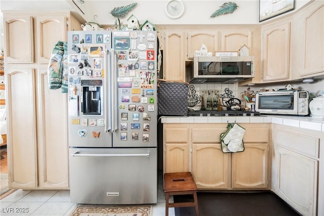 3648 Glen Ridge Way, Las Vegas, NV 89108 - kitchen with stainless steel appliances, tile counters, light brown cabinets, and light tile patterned floors