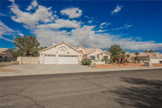 3648 Glen Ridge Way, Las Vegas, NV 89108 - mediterranean / spanish home featuring a garage, stucco siding, concrete driveway, and a residential view