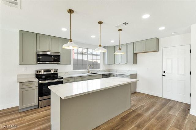 4135 E Harmon Ave, Las Vegas, NV 89121 - kitchen featuring appliances with stainless steel finishes, light wood-type flooring, hanging light fixtures, and recessed lighting