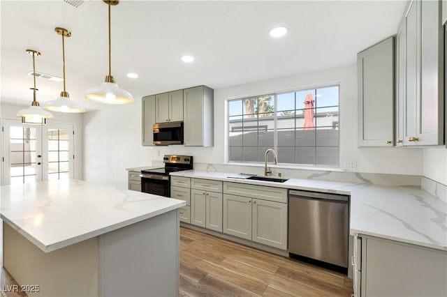 4135 E Harmon Ave, Las Vegas, NV 89121 - kitchen with stainless steel appliances, plenty of natural light, recessed lighting, light wood-style flooring, and light stone countertops