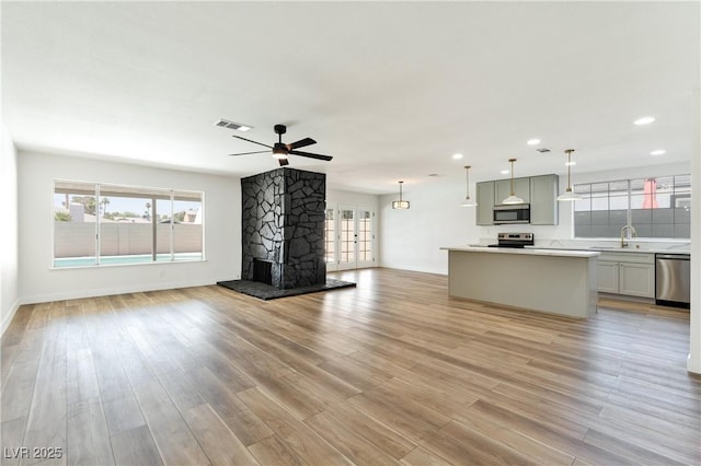 4135 E Harmon Ave, Las Vegas, NV 89121 - unfurnished living room with plenty of natural light, light wood-style flooring, a ceiling fan, and recessed lighting