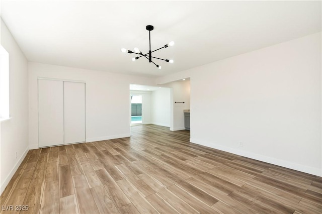 4135 E Harmon Ave, Las Vegas, NV 89121 - unfurnished living room with a chandelier and light wood-style floors