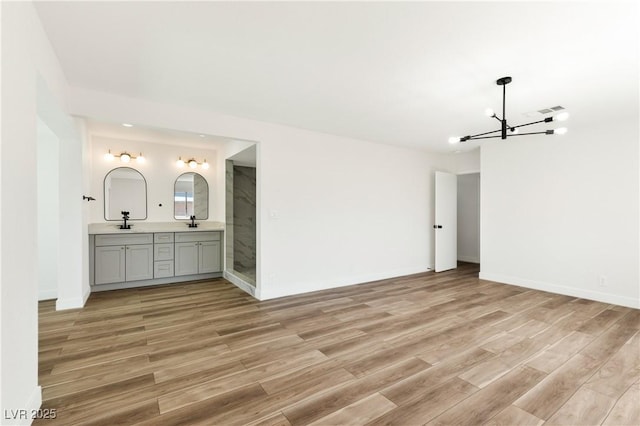 4135 E Harmon Ave, Las Vegas, NV 89121 - unfurnished room featuring a chandelier and light wood-style flooring