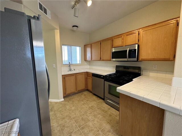 1050 E Cactus Ave Unit 2086, Las Vegas, NV 89183 - kitchen with appliances with stainless steel finishes, tile counters, and light tile patterned floors