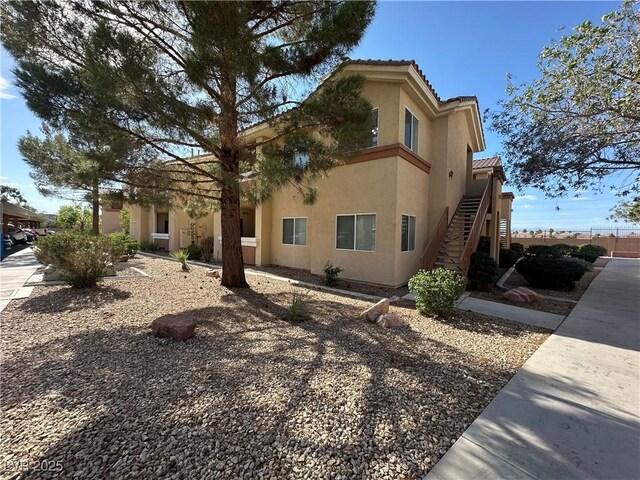 1050 E Cactus Ave Unit 2086, Las Vegas, NV 89183 - view of side of home featuring stucco siding, stairs, and a tile roof