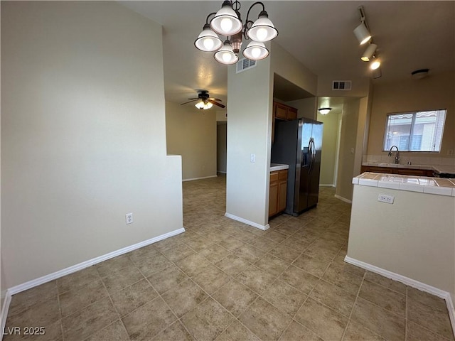 1050 E Cactus Ave Unit 2086, Las Vegas, NV 89183 - kitchen featuring stainless steel fridge, tile counters, a chandelier, a ceiling fan, and brown cabinets