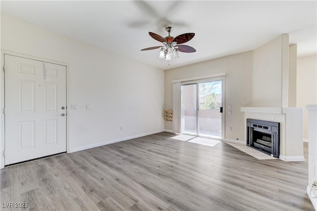 1050 E Cactus Ave Unit 2110, Las Vegas, NV 89183 - unfurnished living room featuring a ceiling fan, light wood finished floors, and a fireplace with flush hearth