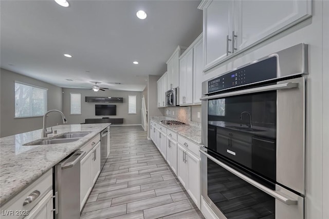12313 Old Muirfield St, Las Vegas, NV 89141 - kitchen featuring appliances with stainless steel finishes, wood finish floors, white cabinetry, open floor plan, and recessed lighting