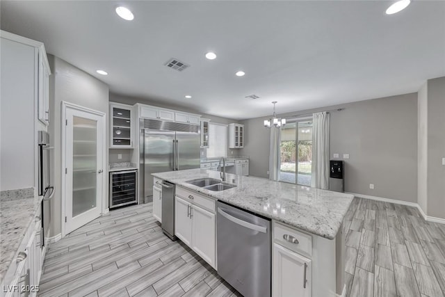 12313 Old Muirfield St, Las Vegas, NV 89141 - kitchen with stainless steel appliances, beverage cooler, wood finish floors, white cabinets, and recessed lighting