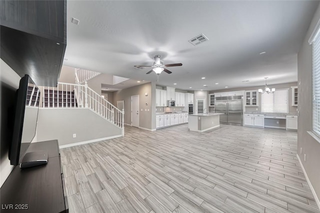 12313 Old Muirfield St, Las Vegas, NV 89141 - unfurnished living room with stairway, light wood-style floors, a ceiling fan, recessed lighting, and a chandelier