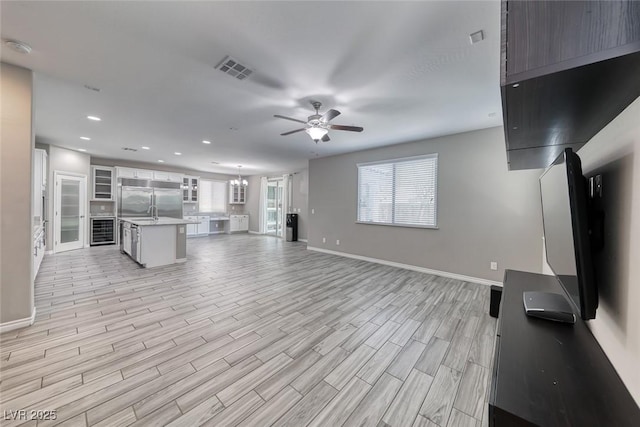 12313 Old Muirfield St, Las Vegas, NV 89141 - unfurnished living room with ceiling fan, light wood-type flooring, healthy amount of natural light, recessed lighting, and wine cooler