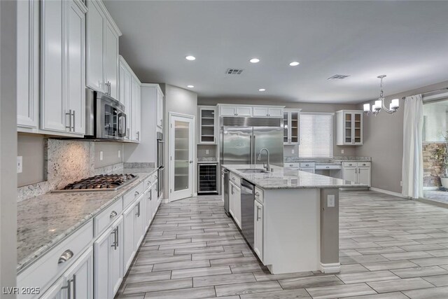 12313 Old Muirfield St, Las Vegas, NV 89141 - kitchen featuring stainless steel appliances, beverage cooler, wood finish floors, a chandelier, and recessed lighting