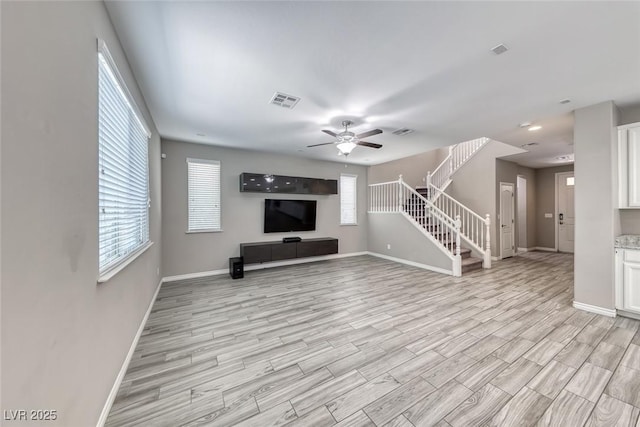 12313 Old Muirfield St, Las Vegas, NV 89141 - unfurnished living room with stairway, light wood-style flooring, and ceiling fan