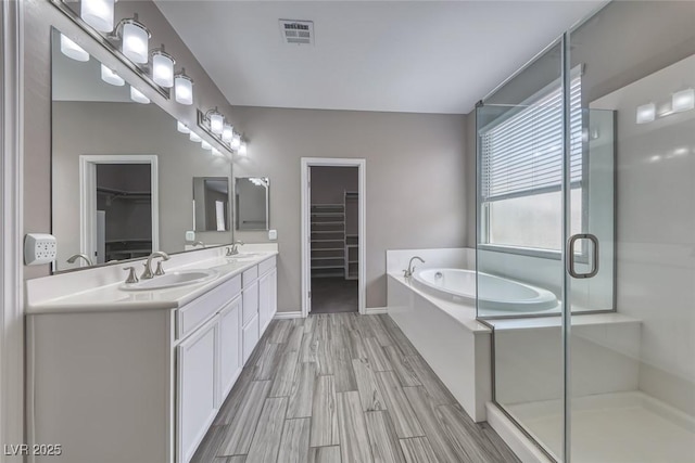 12313 Old Muirfield St, Las Vegas, NV 89141 - full bathroom with a spacious closet, double vanity, a garden tub, and a shower stall