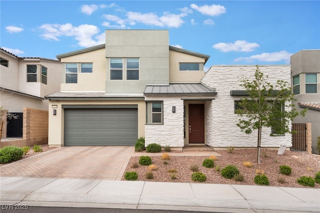 10280 Midnight Meteor Ave, Las Vegas, NV 89166 - view of property with decorative driveway, a garage, stucco siding, a standing seam roof, and stone siding