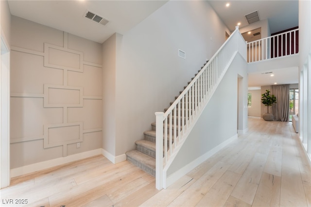 10280 Midnight Meteor Ave, Las Vegas, NV 89166 - staircase featuring hardwood / wood-style flooring, recessed lighting, and a towering ceiling