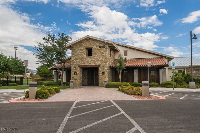 10280 Midnight Meteor Ave, Las Vegas, NV 89166 - view of front facade with stone siding, stucco siding, and uncovered parking