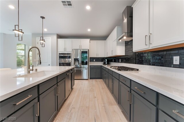 10280 Midnight Meteor Ave, Las Vegas, NV 89166 - kitchen featuring appliances with stainless steel finishes, wall chimney exhaust hood, gray cabinetry, backsplash, and white cabinetry