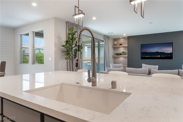 10280 Midnight Meteor Ave, Las Vegas, NV 89166 - kitchen featuring light stone counters, recessed lighting, decorative light fixtures, and open floor plan